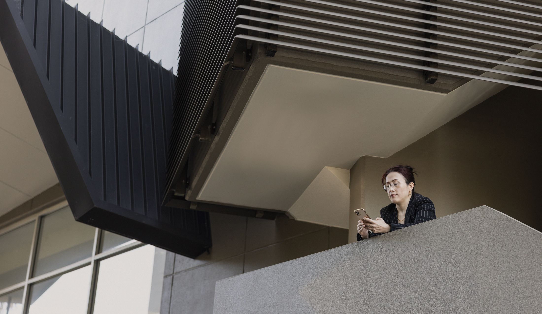Eva Liu overlooking a Sydney building from a balcony